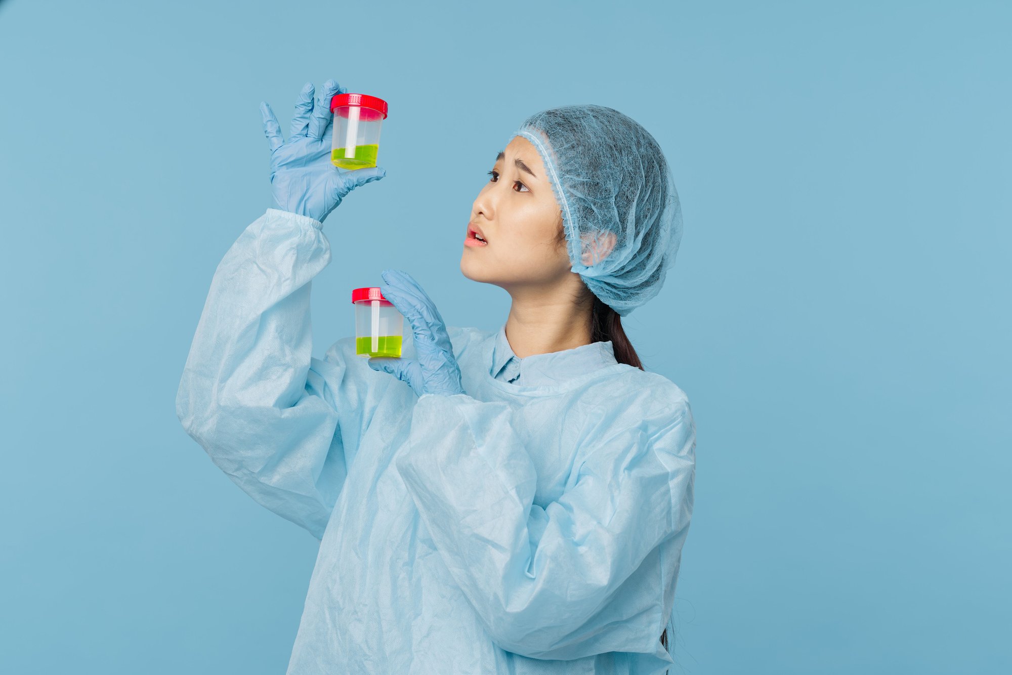 Female in a Blue Scrub Suit Holding Urine Sample